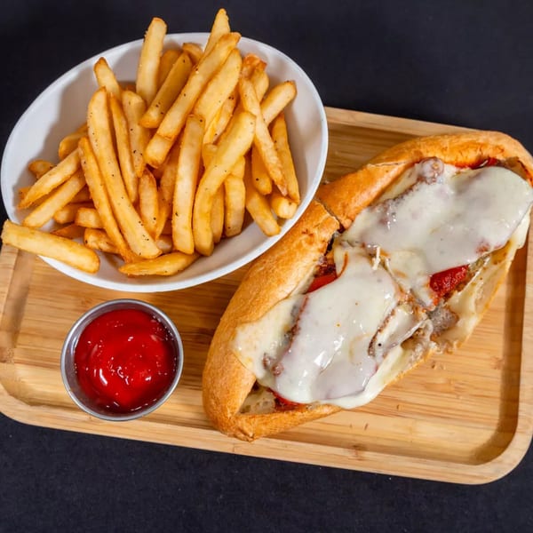 A Sorianos Pizzeria cheesesteak with melted cheese, a side of fries, and ketchup on a wooden tray.
