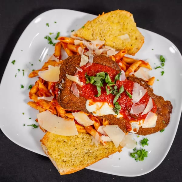 Chicken Parmesan with penne pasta, marinara sauce, melted mozzarella, parmesan cheese, and garlic bread.
